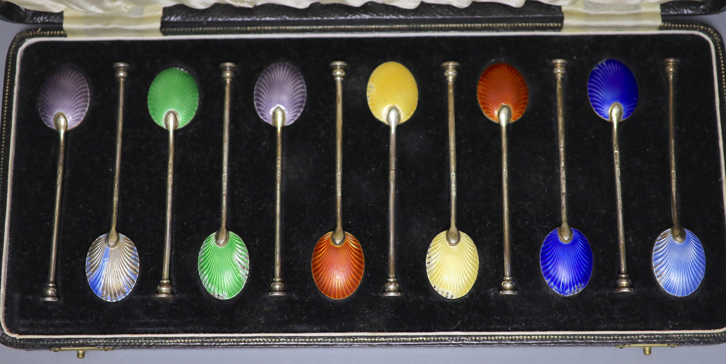 A cased set of twelve George V silver and polychrome enamel coffee spoons (enamel a.f.).